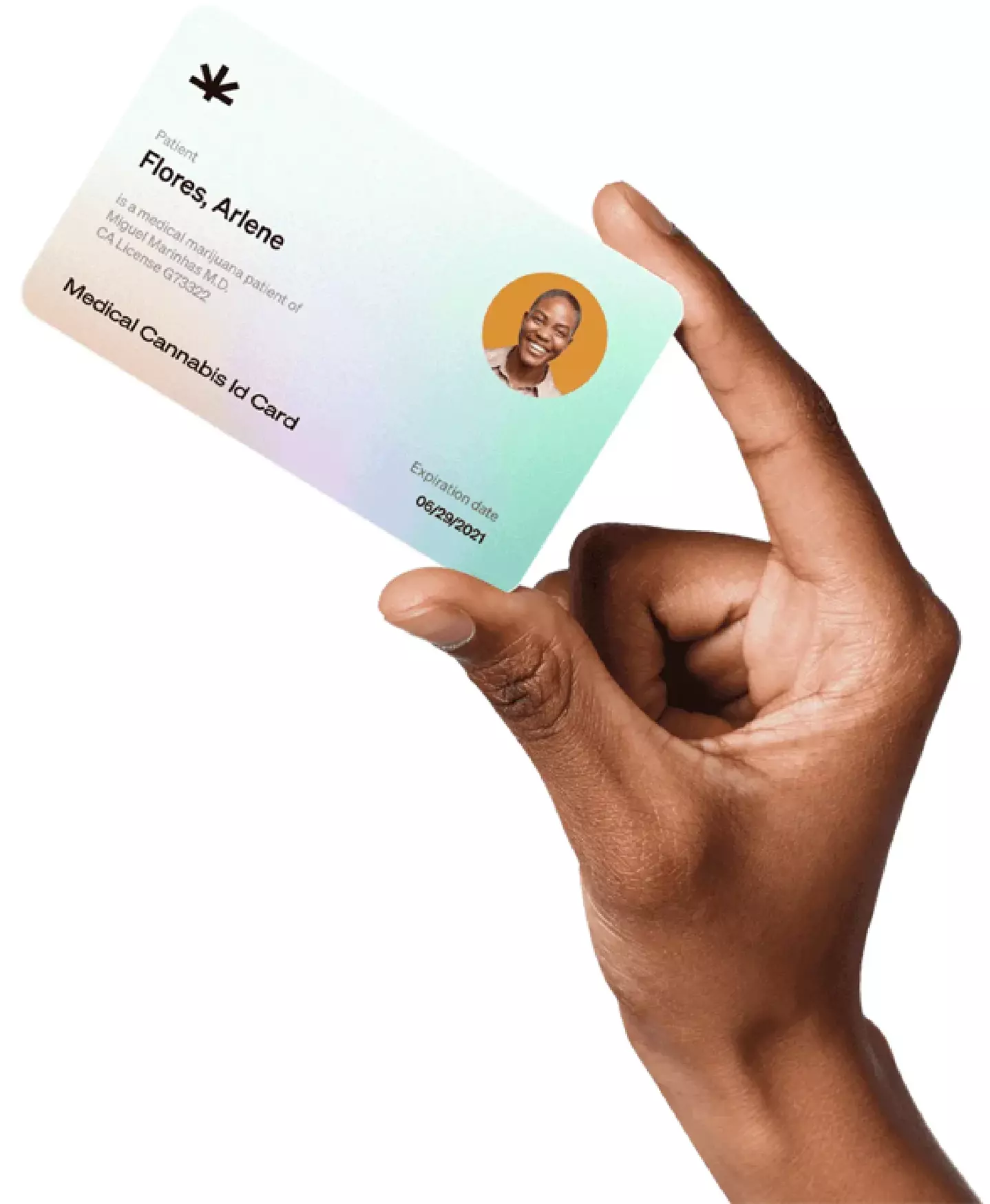 A hand is holding a medical cannabis ID card between the thumb and forefinger. The card, labeled "Patient Flores Ariene," includes a photo of a smiling person, patient ID, date of birth, an expiration date of 08/29/2024, and states that it is a "Medical Cannabis ID Card".